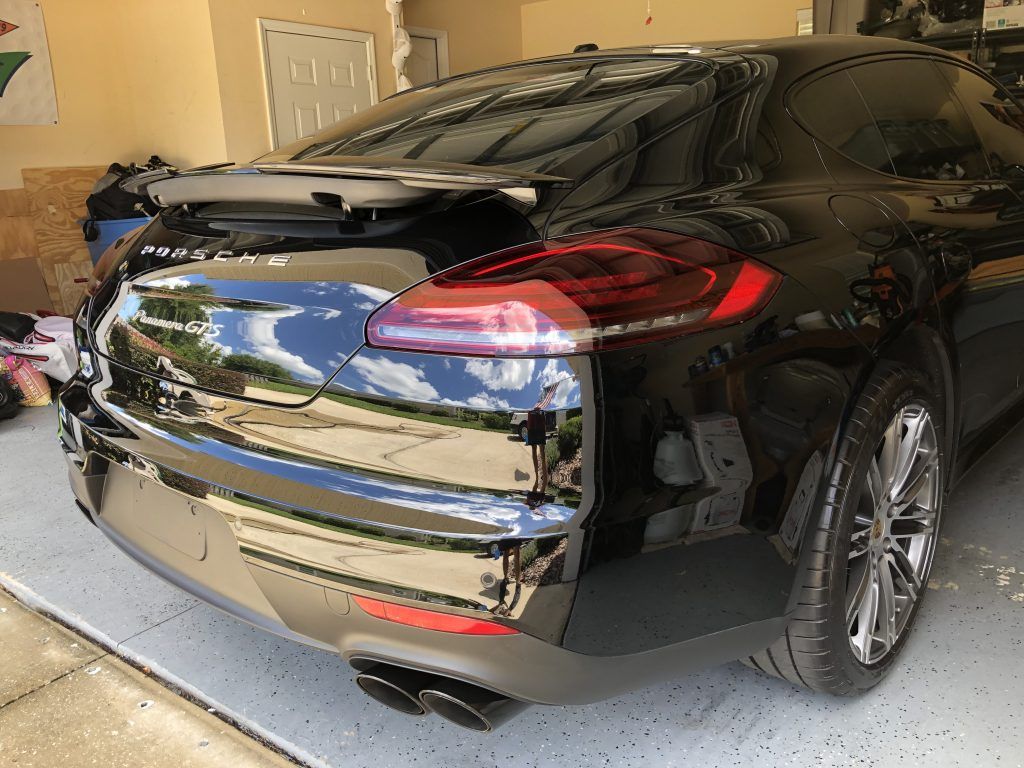 A black car is parked in a garage.