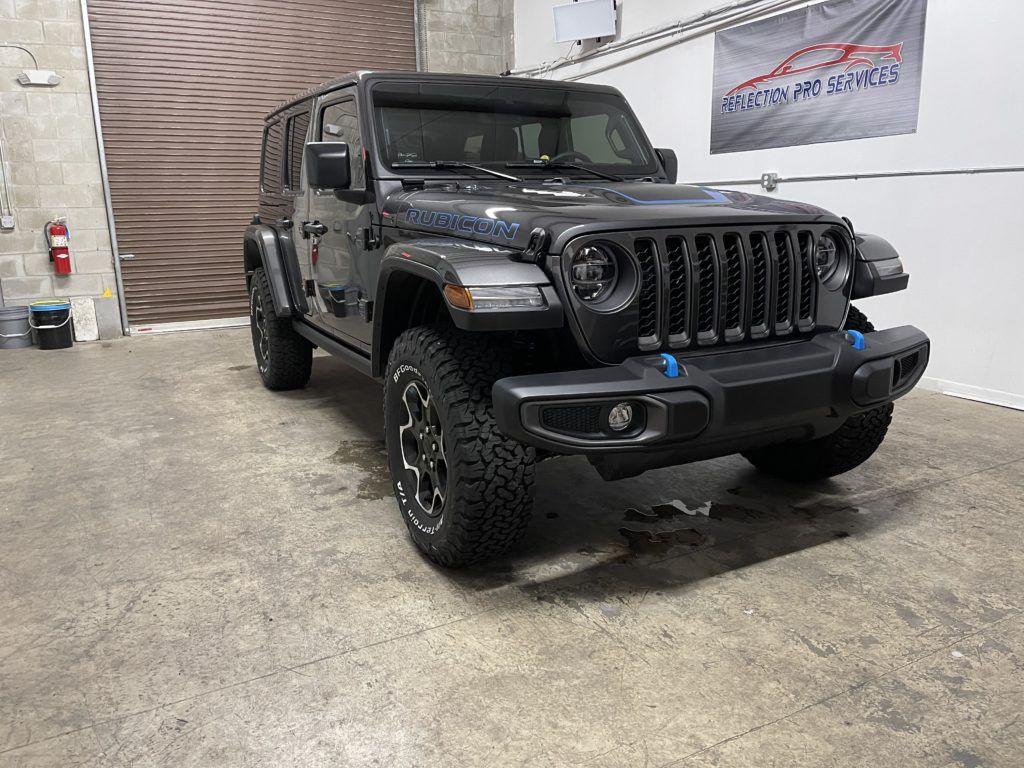 A black jeep wrangler is parked in a garage.