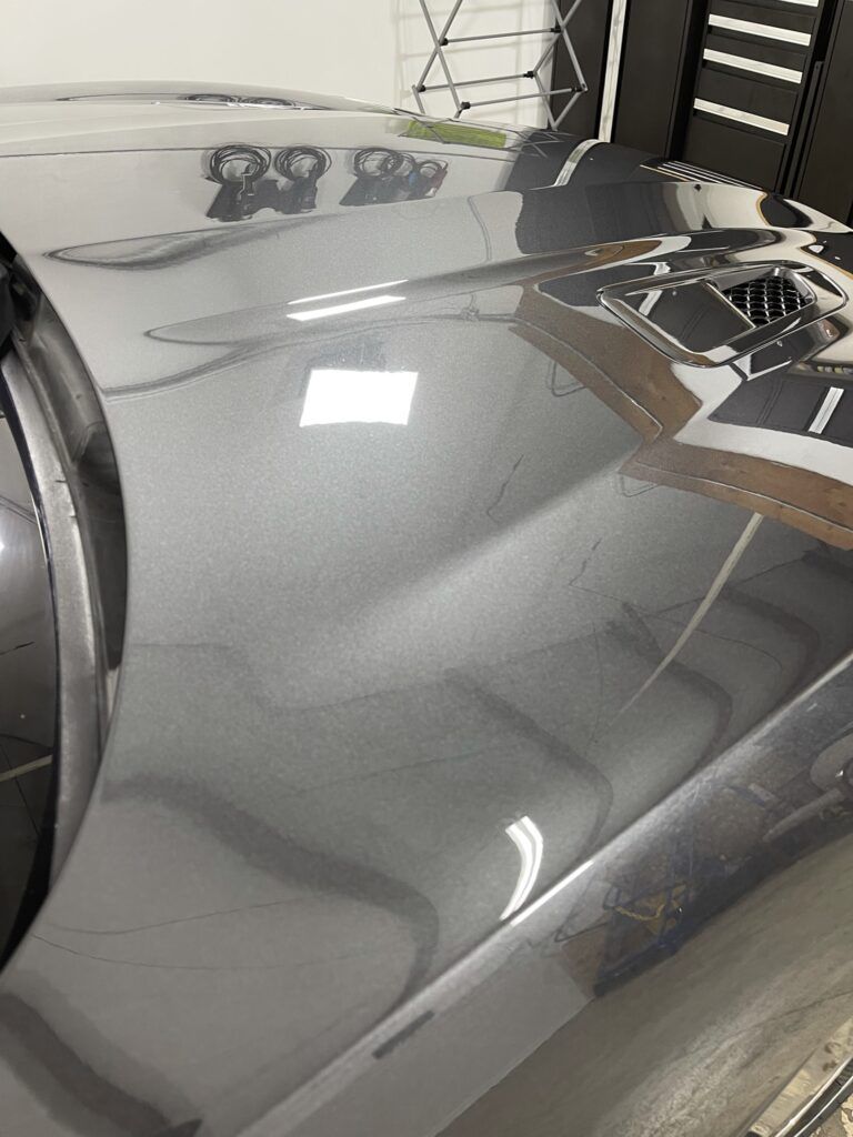A close up of the hood of a car in a garage.