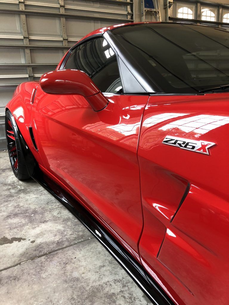A red corvette zr1 is parked in a garage.