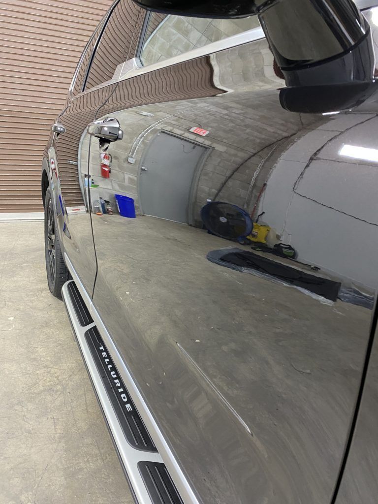 A close up of a car 's side in a garage.