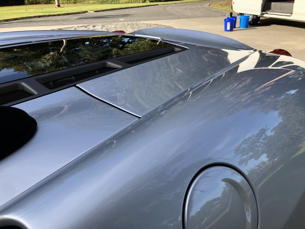 A silver sports car is parked in a parking lot.