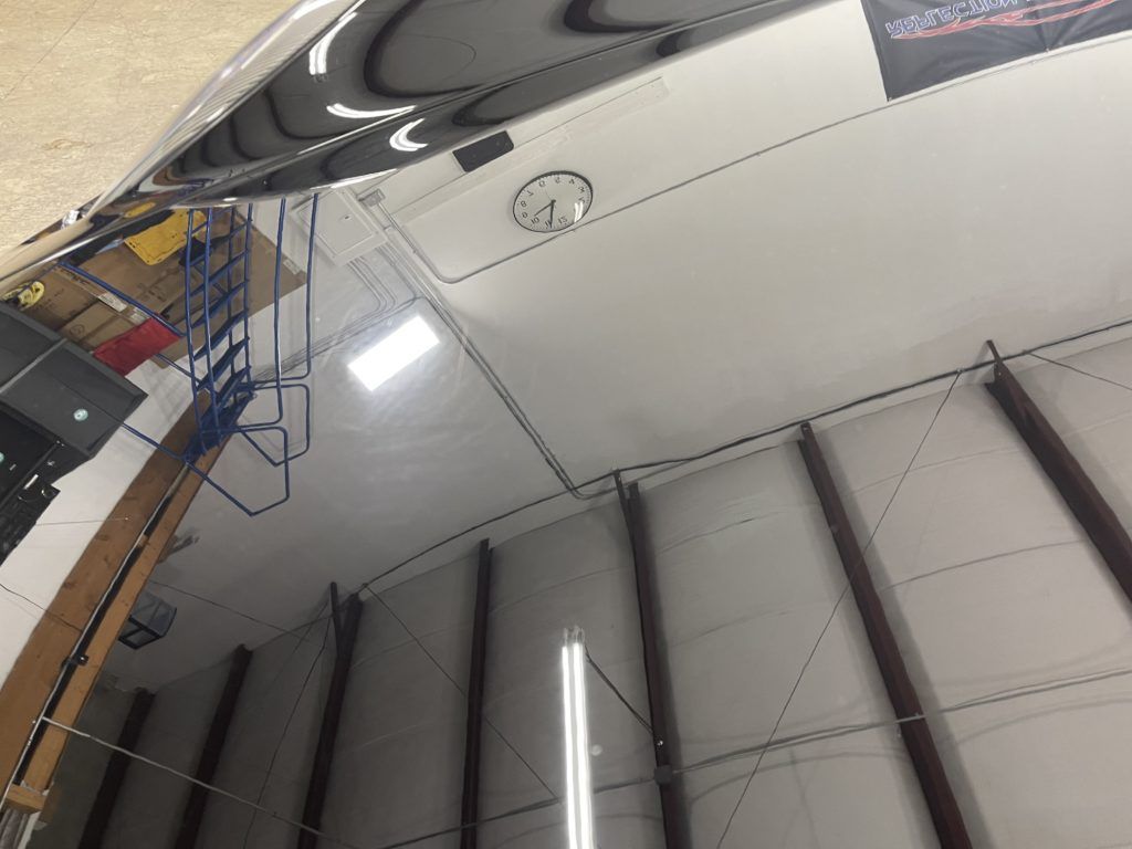 A ceiling with a reflection of a car in it
