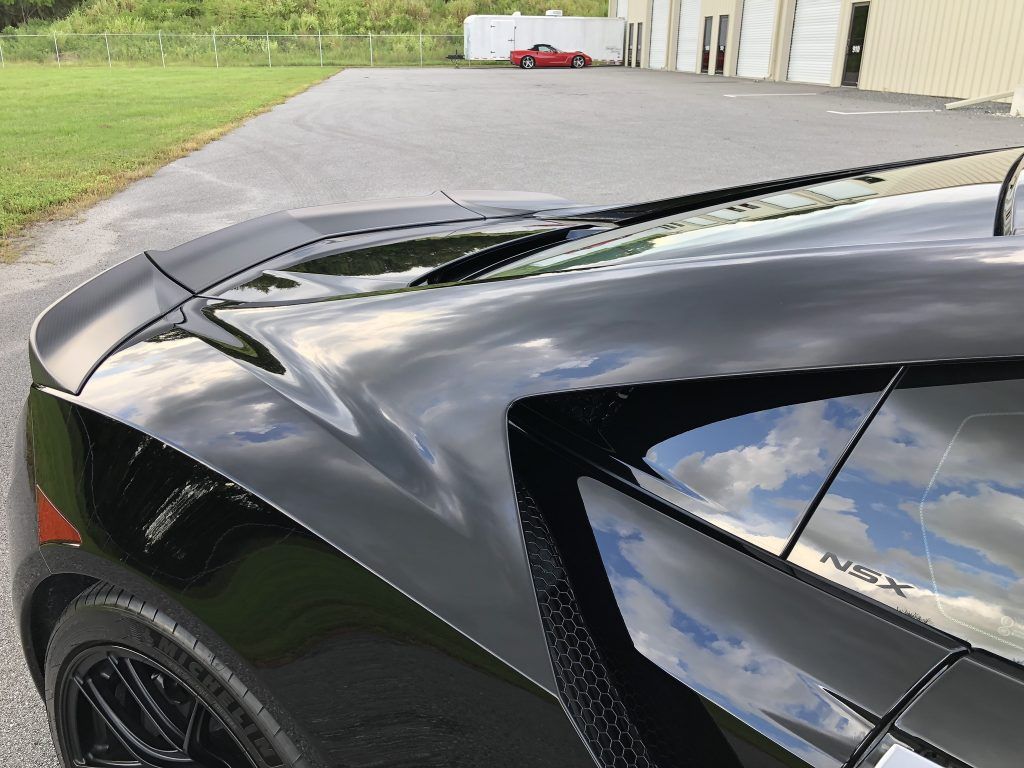 A black sports car is parked on the side of the road