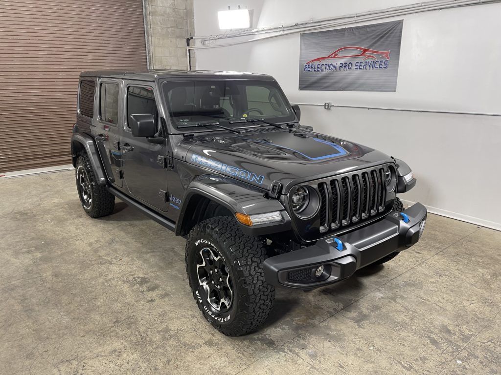 A jeep wrangler is parked in a garage next to a garage door.