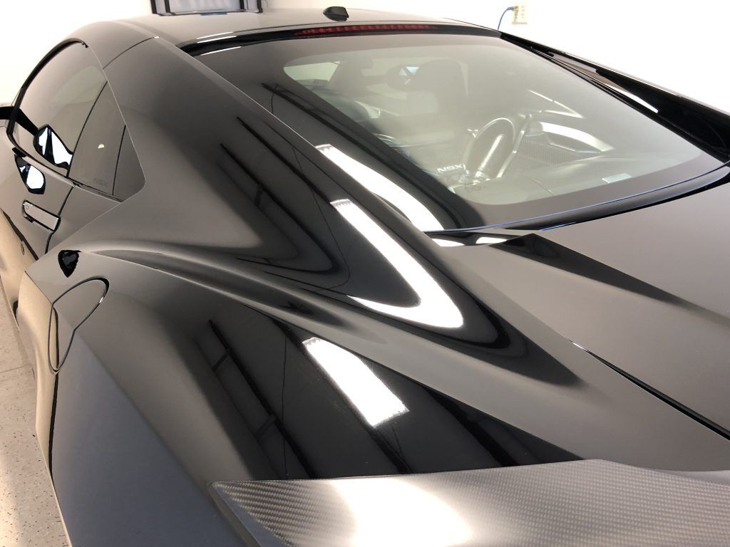 A black sports car is parked in a garage