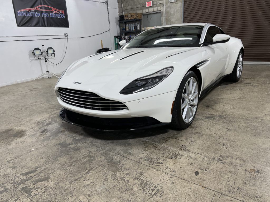 A white sports car is parked in a garage.