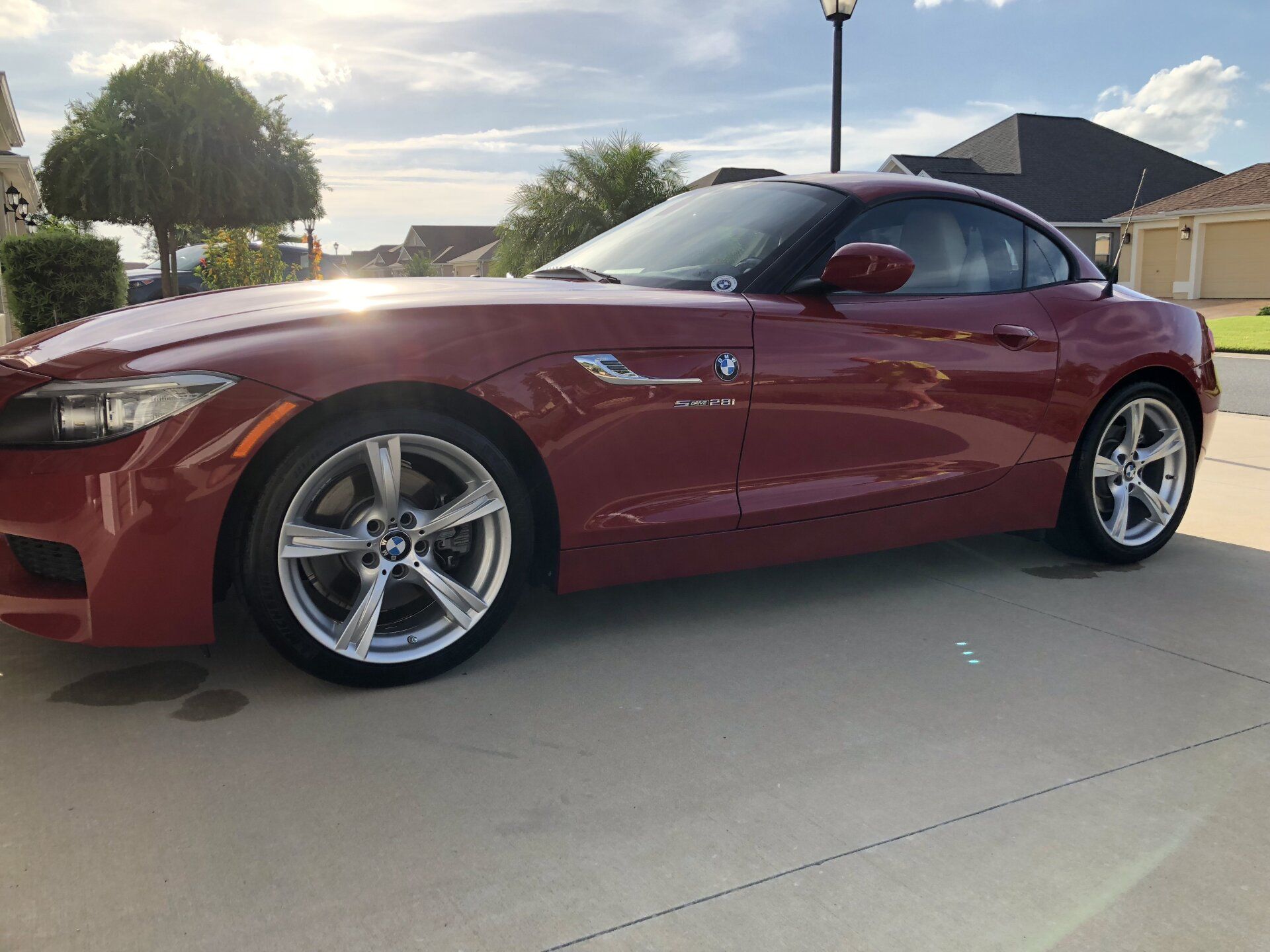 A red bmw z4 is parked in a driveway.