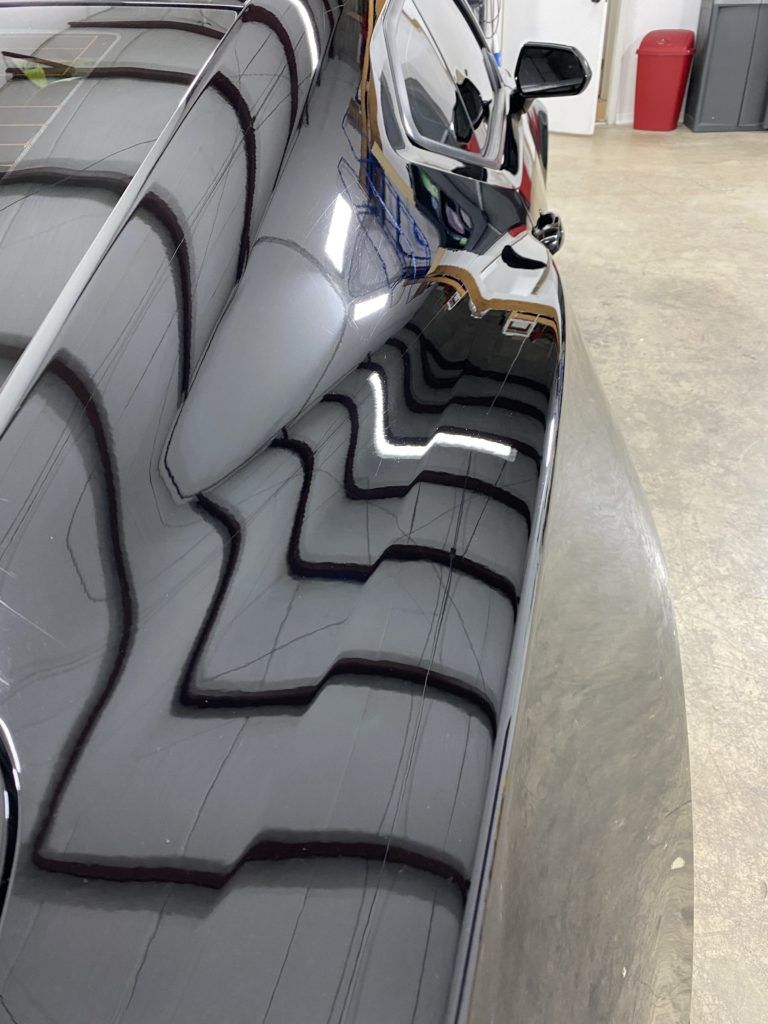 A close up of a car 's side in a garage.