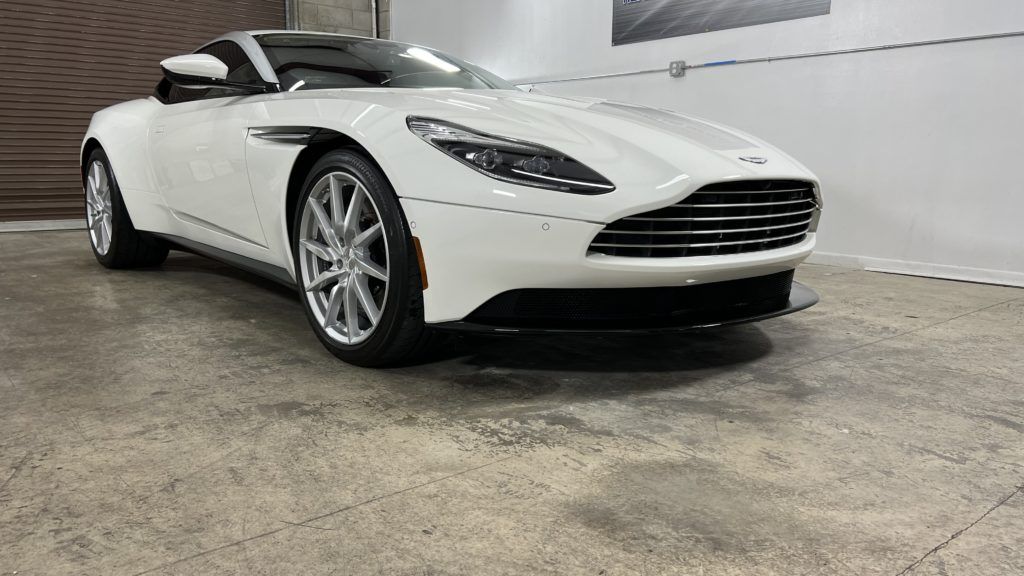 A white sports car is parked in a garage.