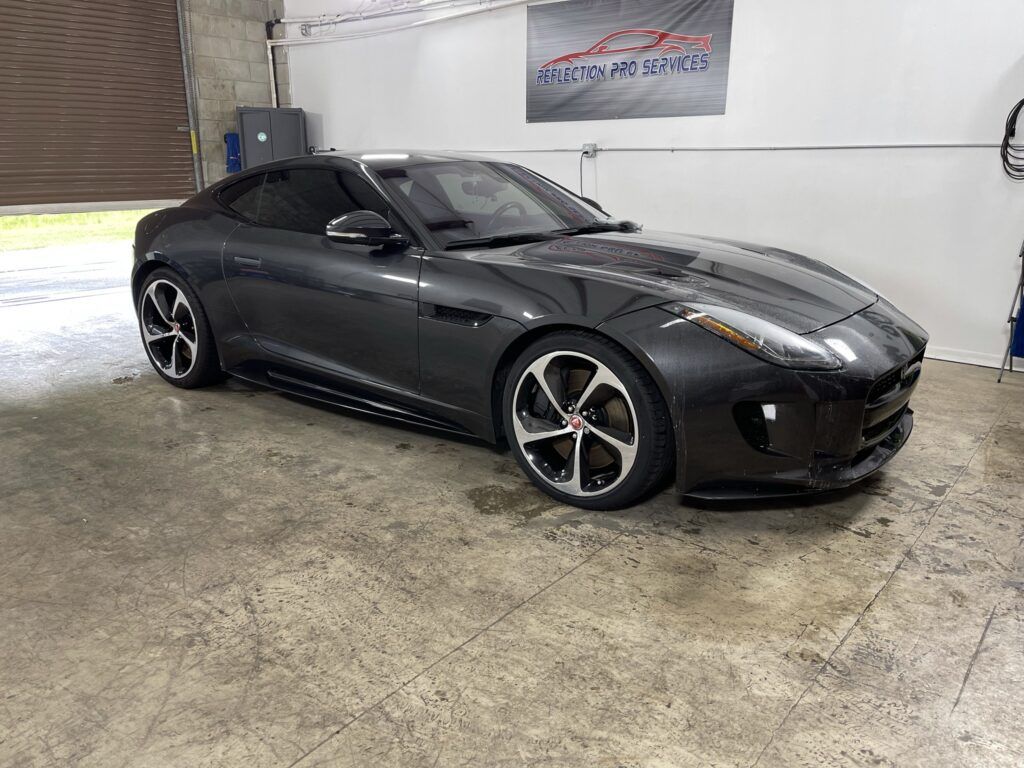 A jaguar f type is parked in a garage.