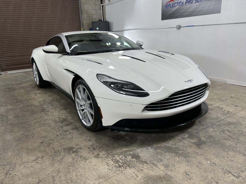 A white sports car is parked in a garage.