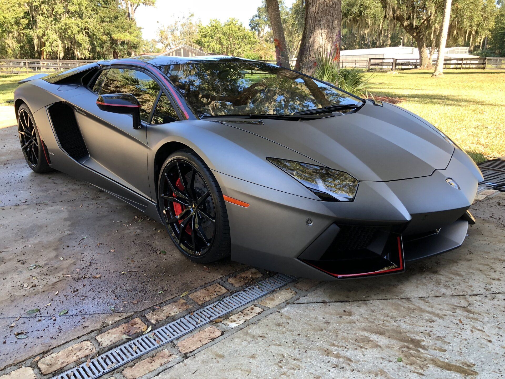 A black lamborghini aventador is parked in a driveway
