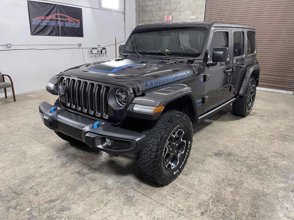 A black jeep wrangler is parked in a garage.