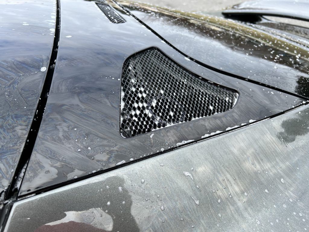 A close up of a car hood with a shark fin on it