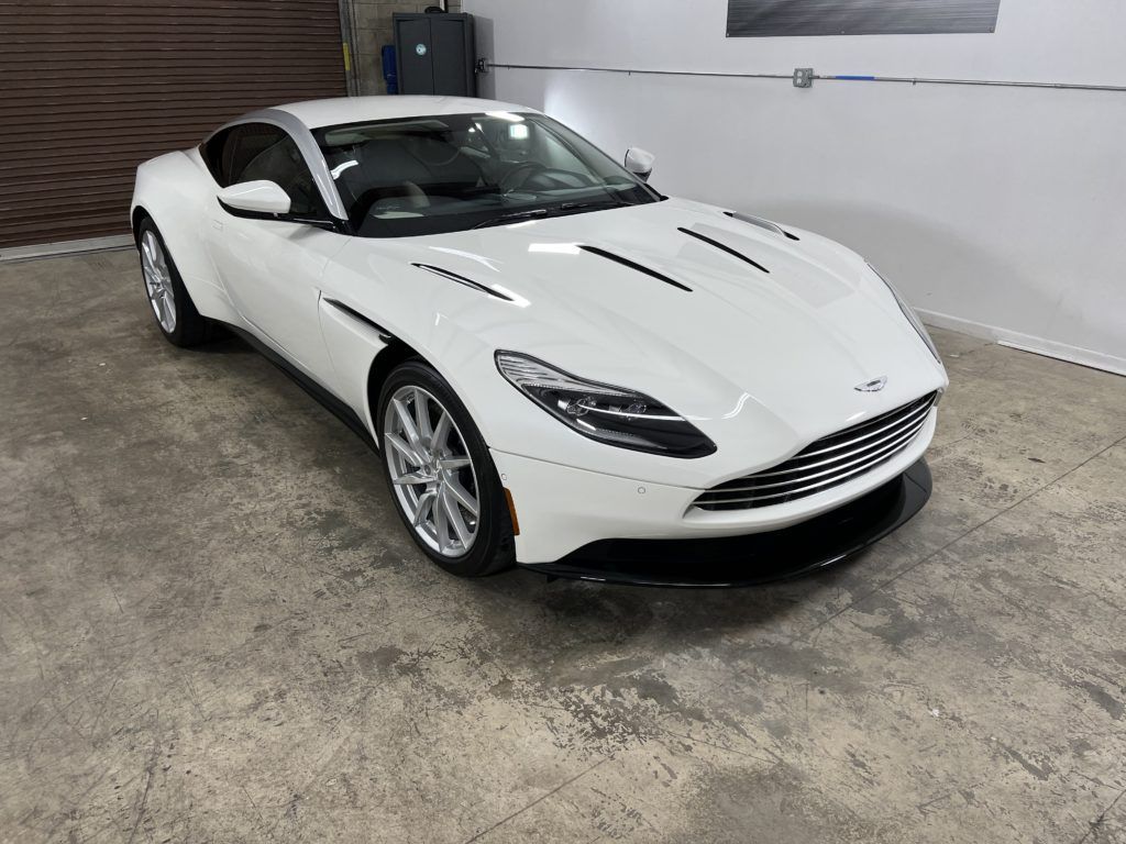 A white sports car is parked in a garage.