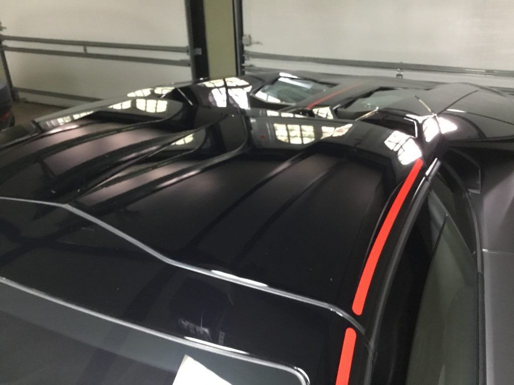 A black car with a red stripe on the roof