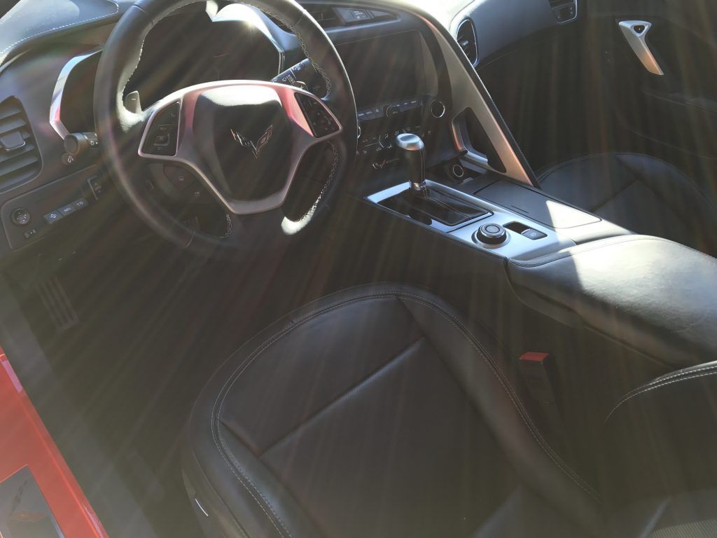 The interior of a sports car with black seats and a steering wheel