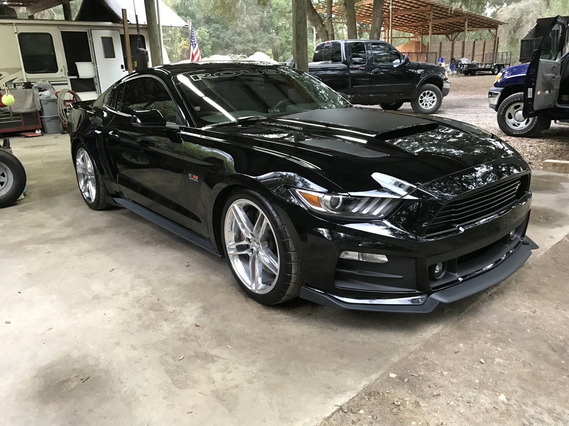 A black ford mustang is parked in a parking lot.