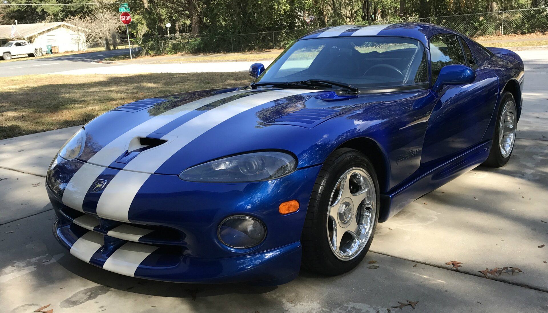 A blue and white dodge viper is parked in a driveway.