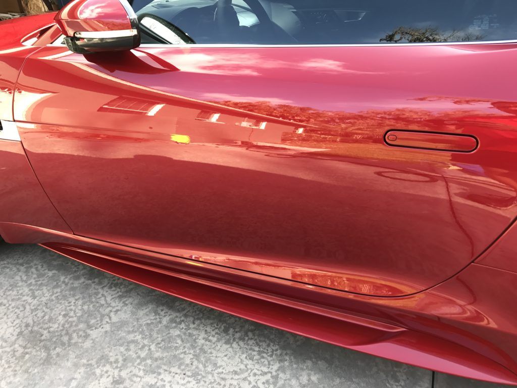A red sports car is parked on the side of the road