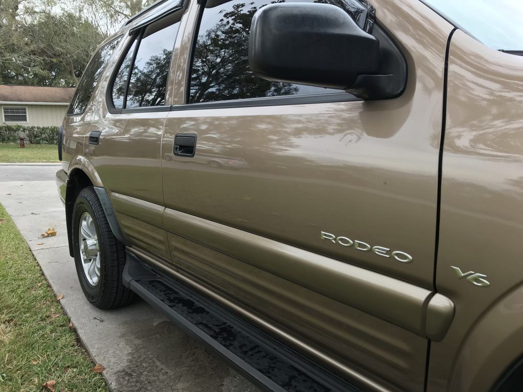 A brown suv is parked on the side of the road