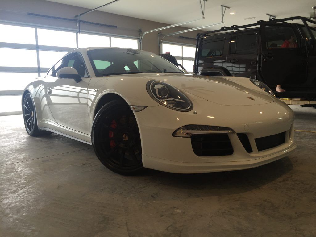 A white porsche 911 gt3 is parked in a garage.