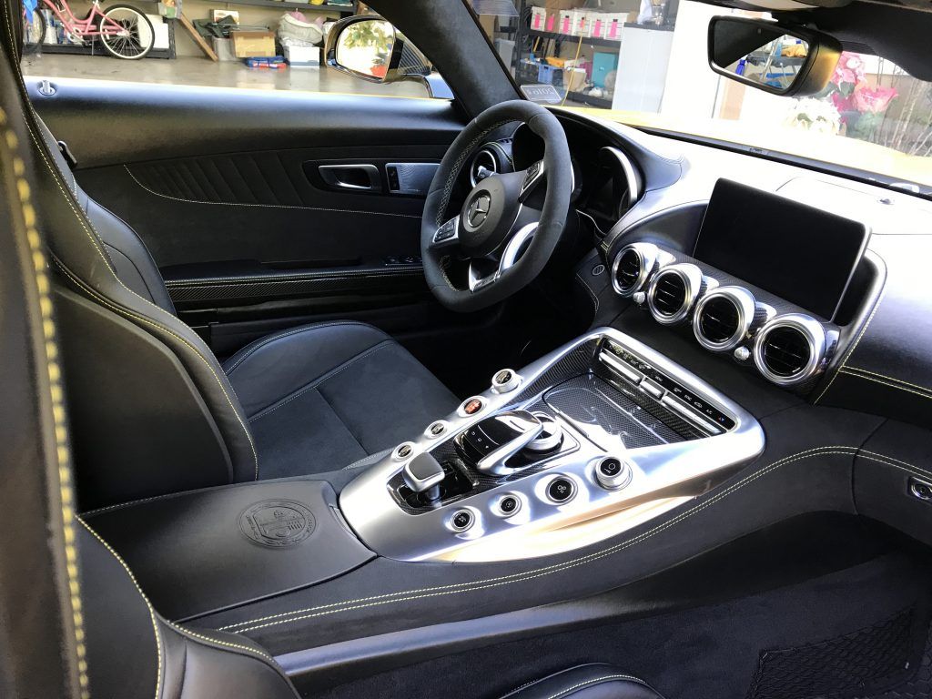 The interior of a black sports car with a steering wheel.