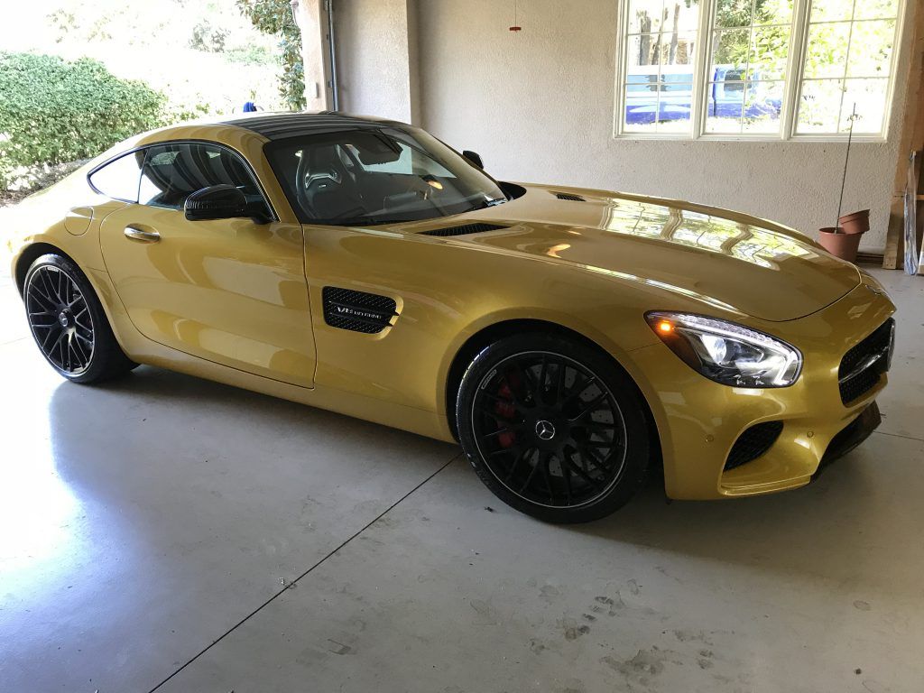 A yellow sports car is parked in a garage.