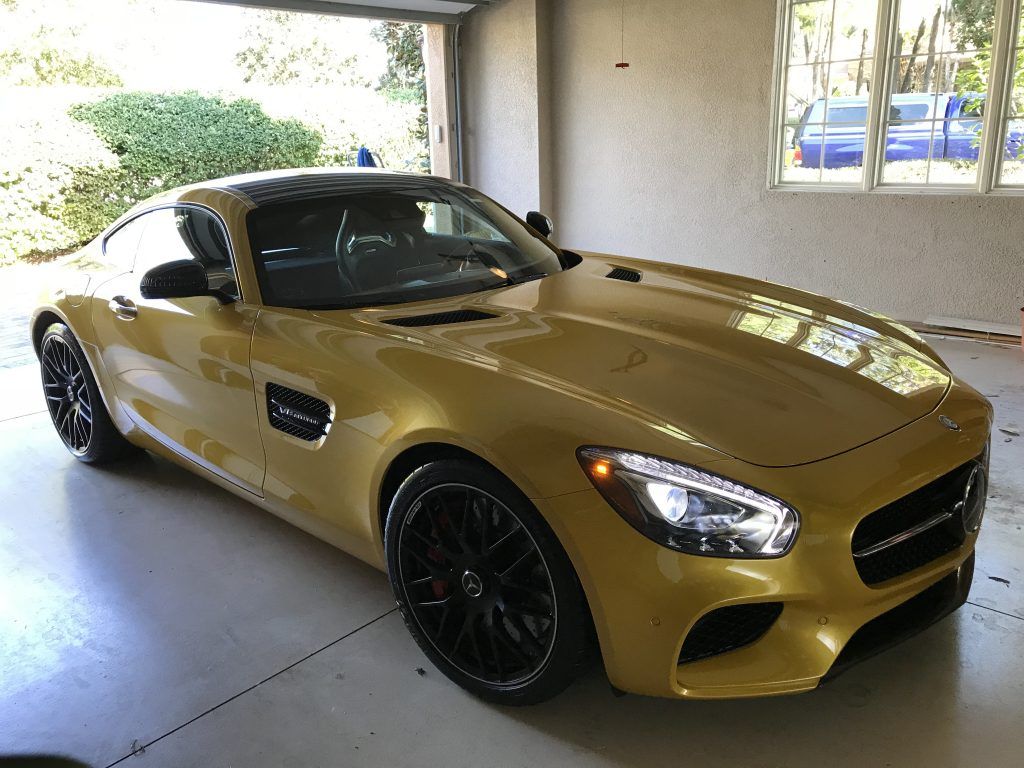 A yellow sports car is parked in a garage.