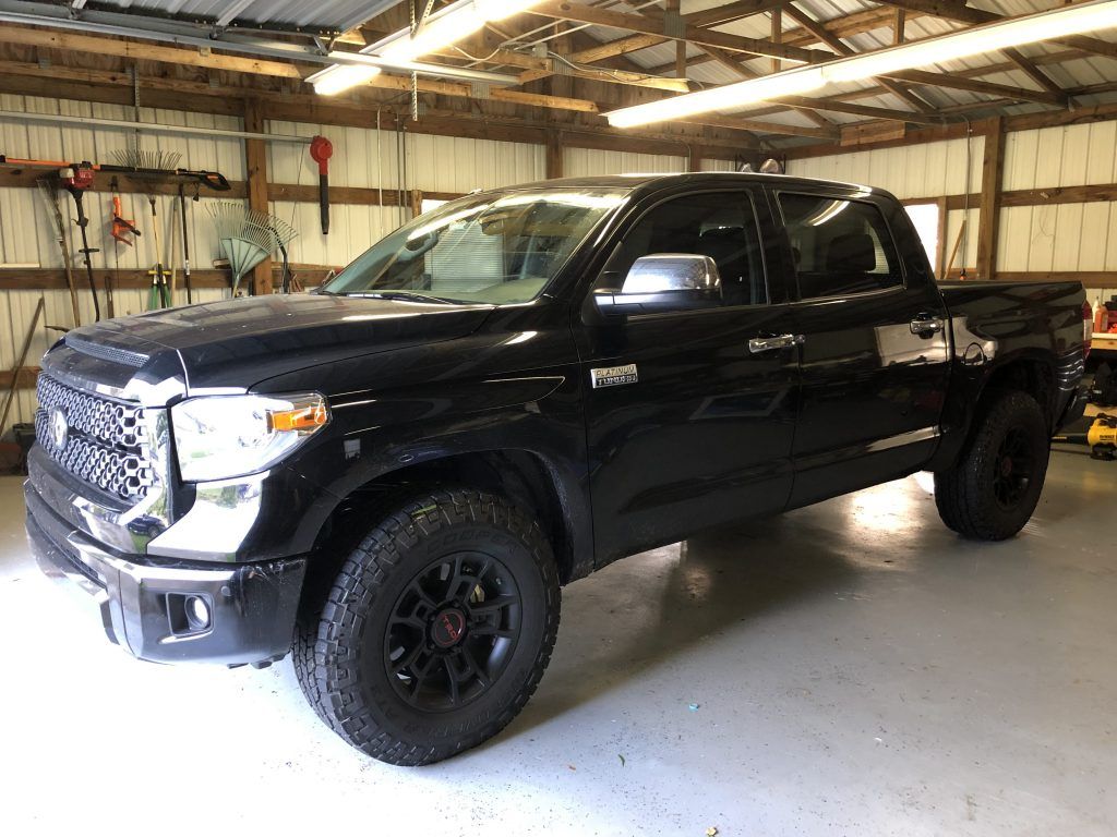 A black toyota tundra is parked in a garage.