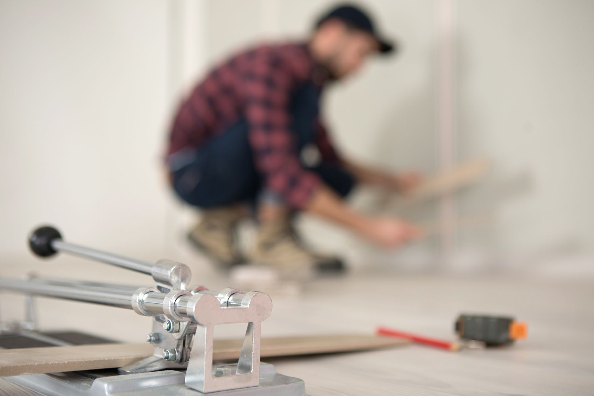Technician performing residential concrete cutting with diamond-blade saw on a basement wall.