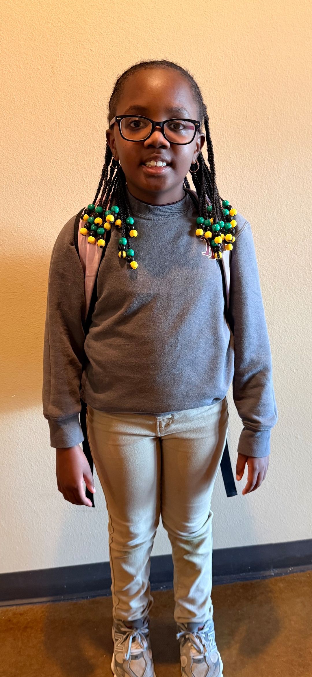After/Before care student smiling against a beige wall