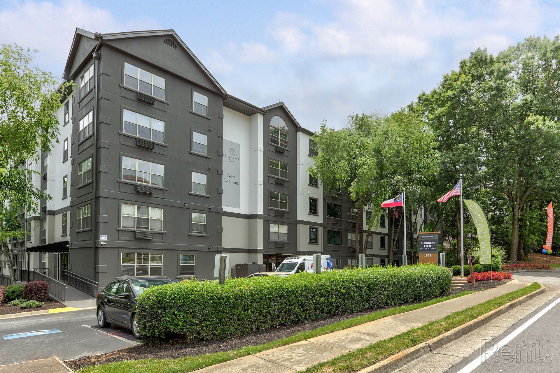 Exterior view of well-maintained landscaping and modern building at Clairmont Crest senior living apartments in Decatur, GA.