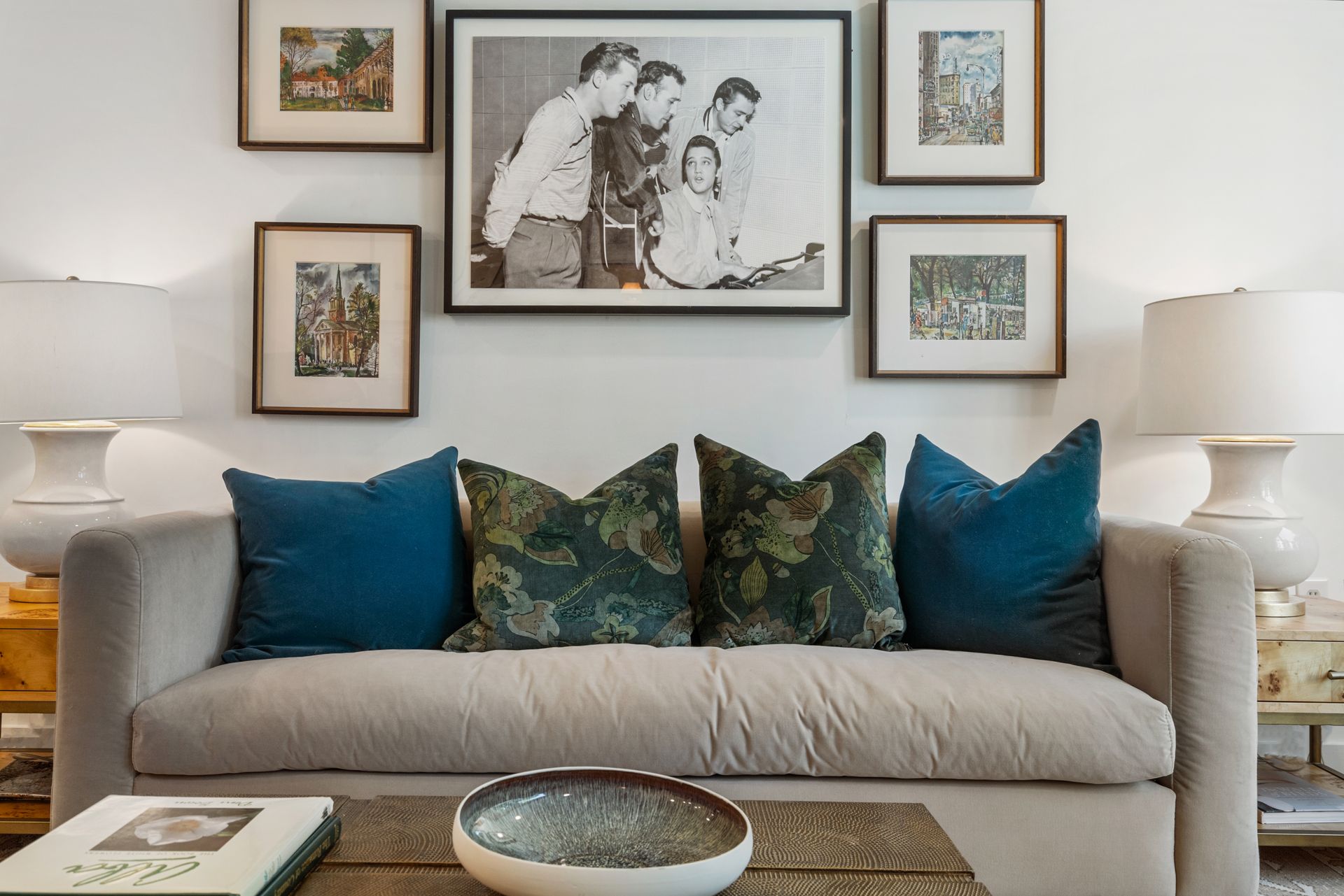 Comfortable couch below a historic photo of Jerry Lee Lewis, Carl Perkins, Elvis Presley, and Johnny Cash in a model home's living area at Clairmont Crest senior living apartments in Decatur, GA.