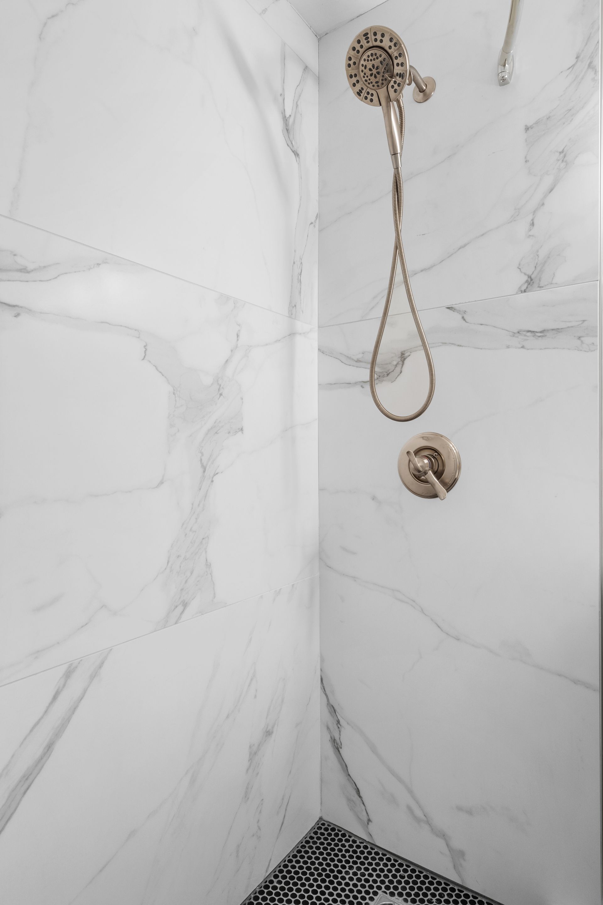 Marbled walls in the shower in a model home's bathroom at Clairmont Crest senior living apartments in Decatur, GA.
