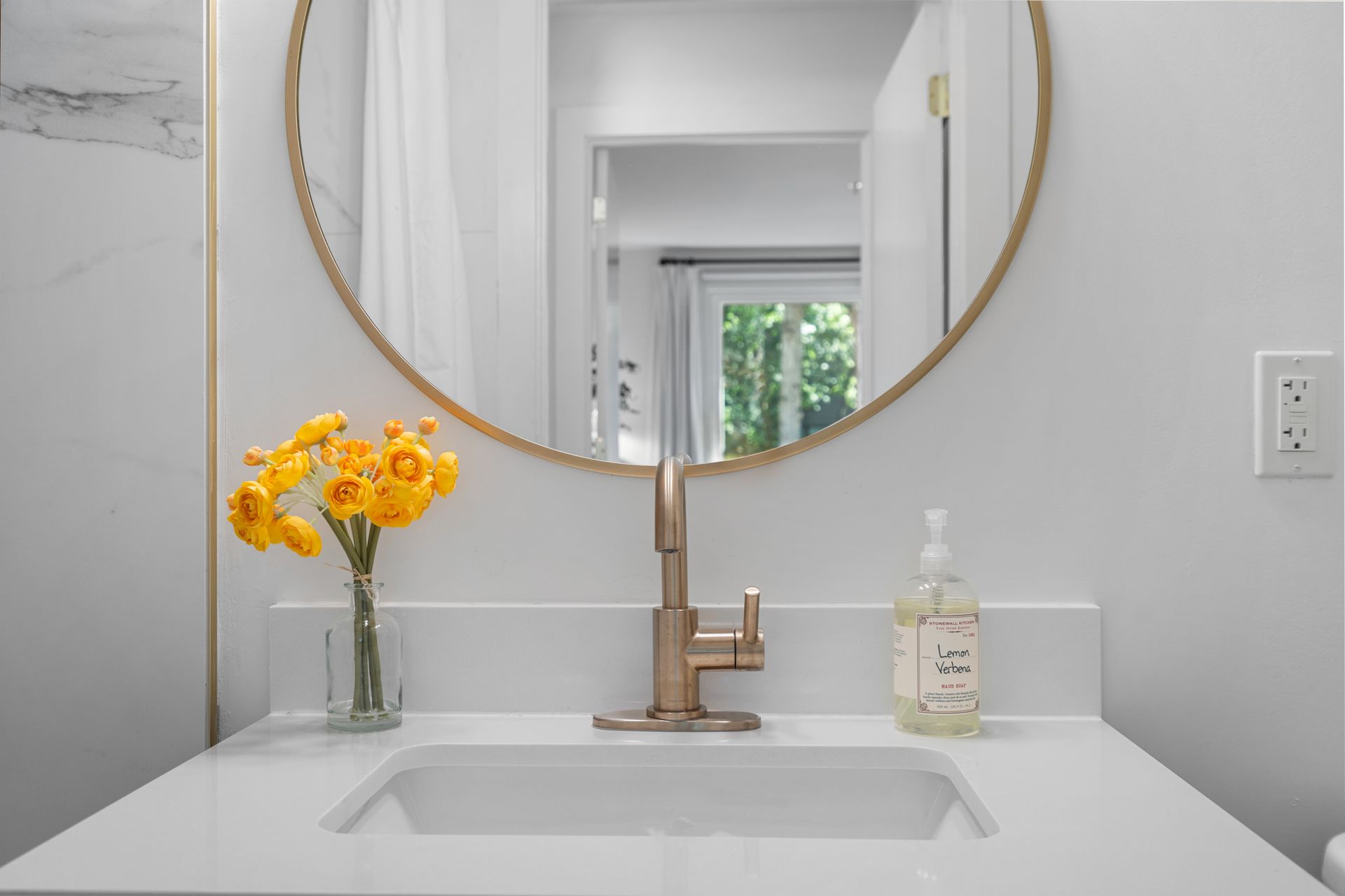 Round mirror above the sink in a model home's bathroom at Clairmont Crest senior living apartments in Decatur, GA.