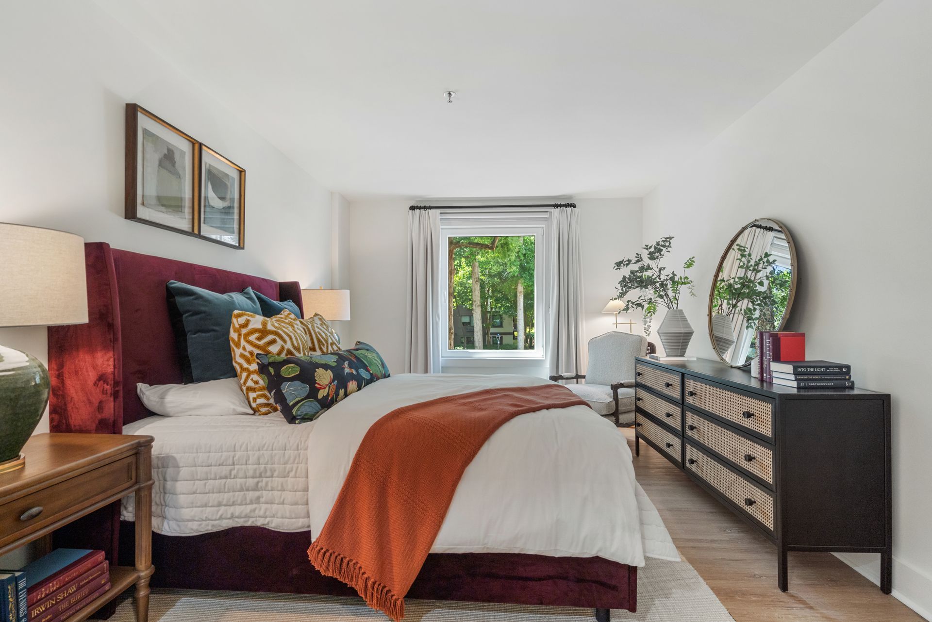 Cozy bedroom with a large bay window in a model home at Clairmont Crest senior living apartments in Decatur, GA.