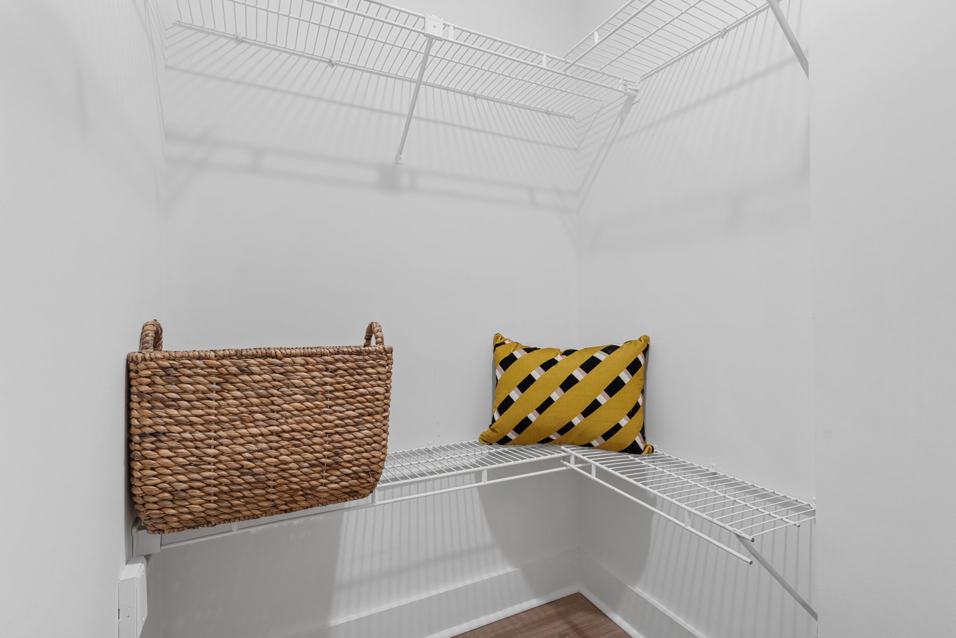 Decorative pillows on ample shelving in a model home's closet at Clairmont Crest senior living apartments in Decatur, GA.