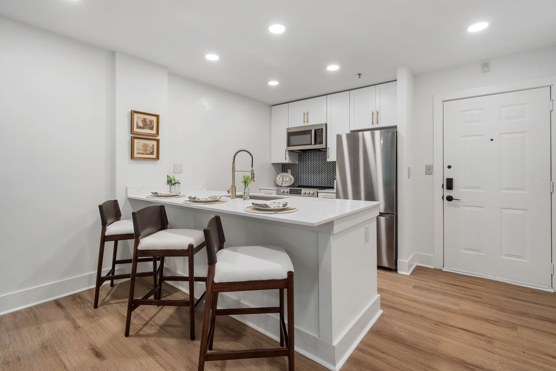 Comfortable chairs providing bar seating at the kitchen island in a model home at Clairmont Crest senior living apartments in Decatur, GA.