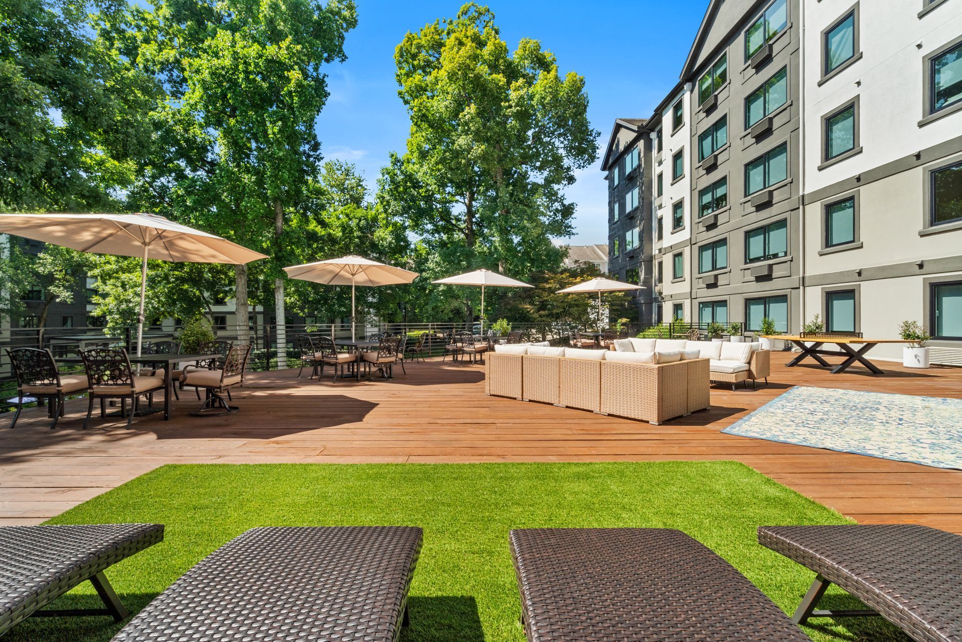 View of a comfortable lounge area on the expansive outdoor deck at Clairmont Crest senior living apartments in Decatur, GA.