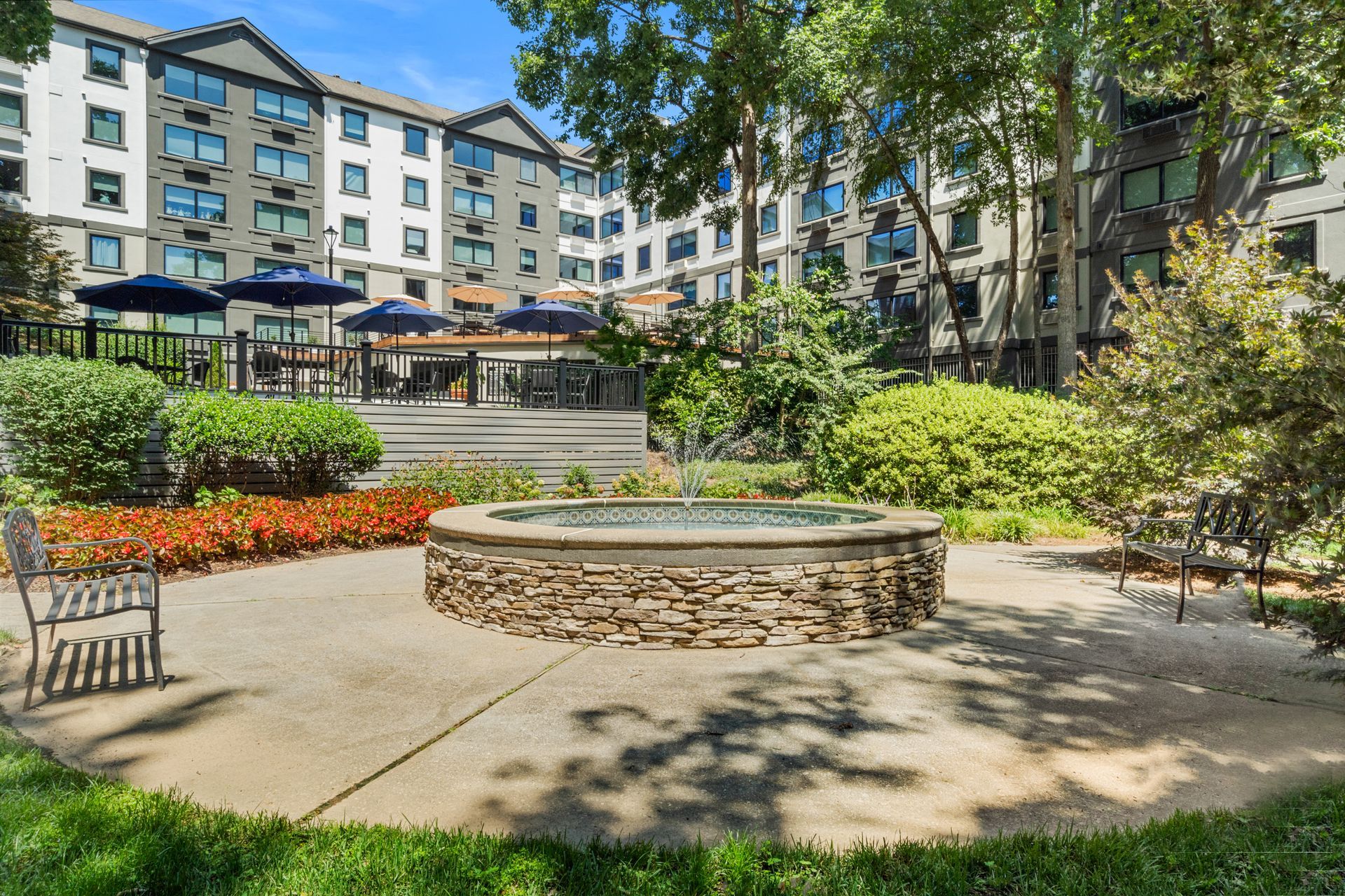 View of the main building from the peaceful fountain area at Clairmont Crest senior living apartments in Decatur, GA.