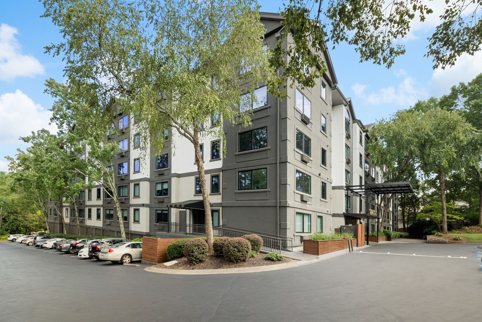 Exterior view of the modern building and green landscaping at Clairmont Crest senior living apartments in Decatur, GA.
