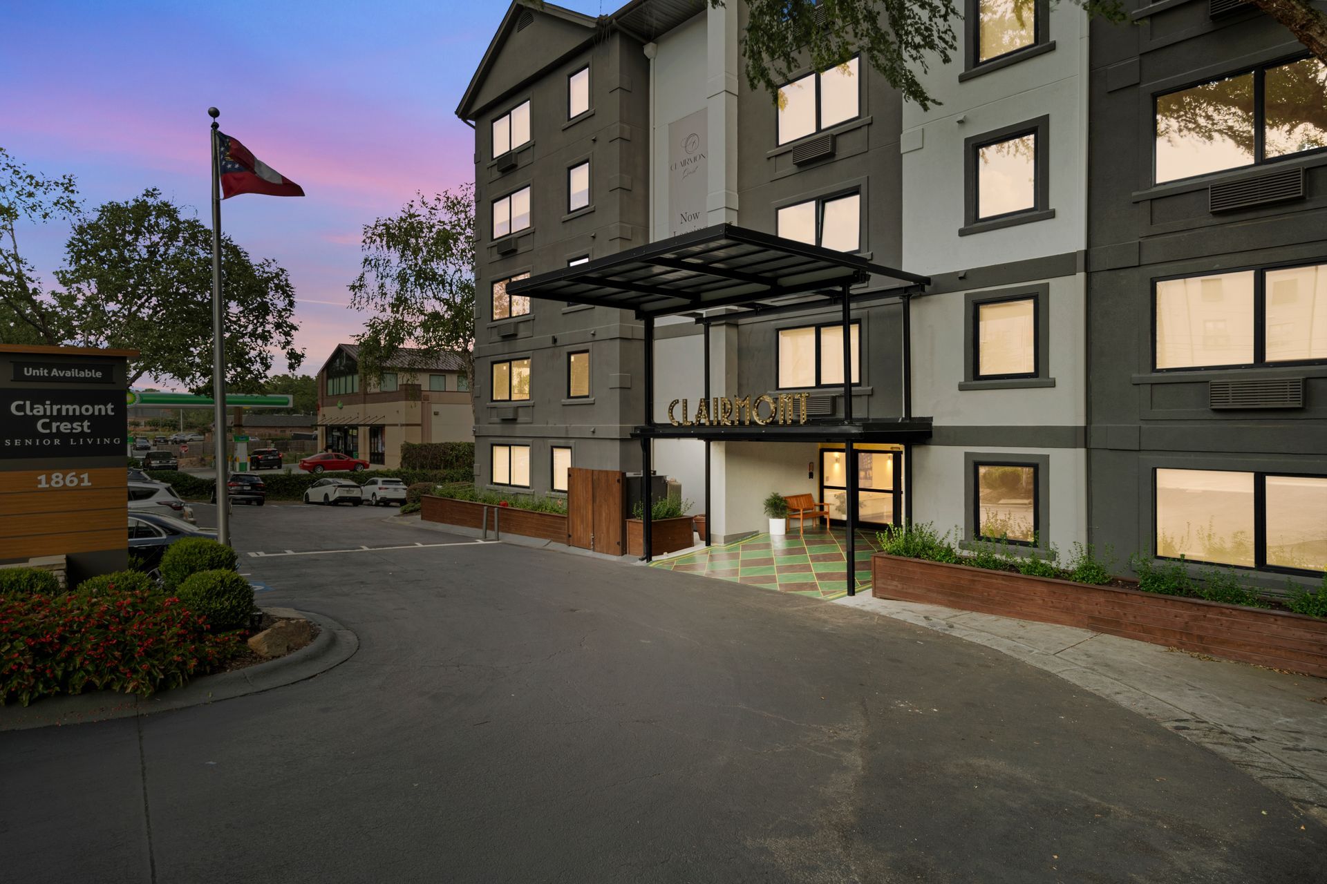 View of the exterior entrance area at dusk at Clairmont Crest senior living apartments in Decatur, GA.