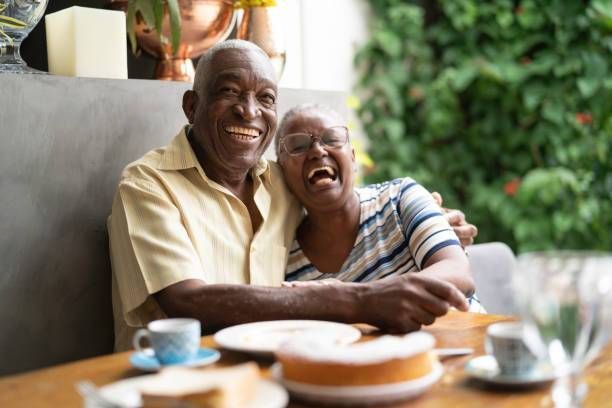 An elderly couple smiling and laughing together at Clairmont Crest senior living apartments in Decatur, GA.