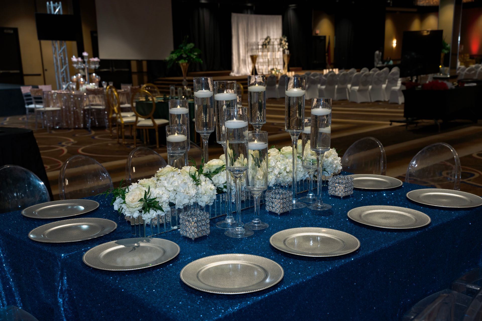 A table with plates , vases , candles and flowers on it.