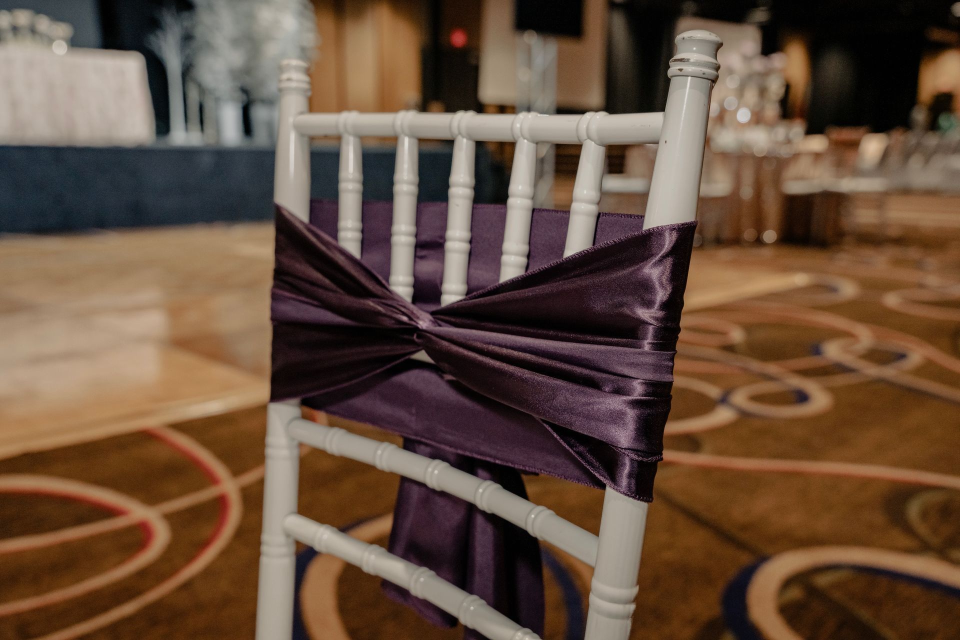 A white chair with a purple bow on it.