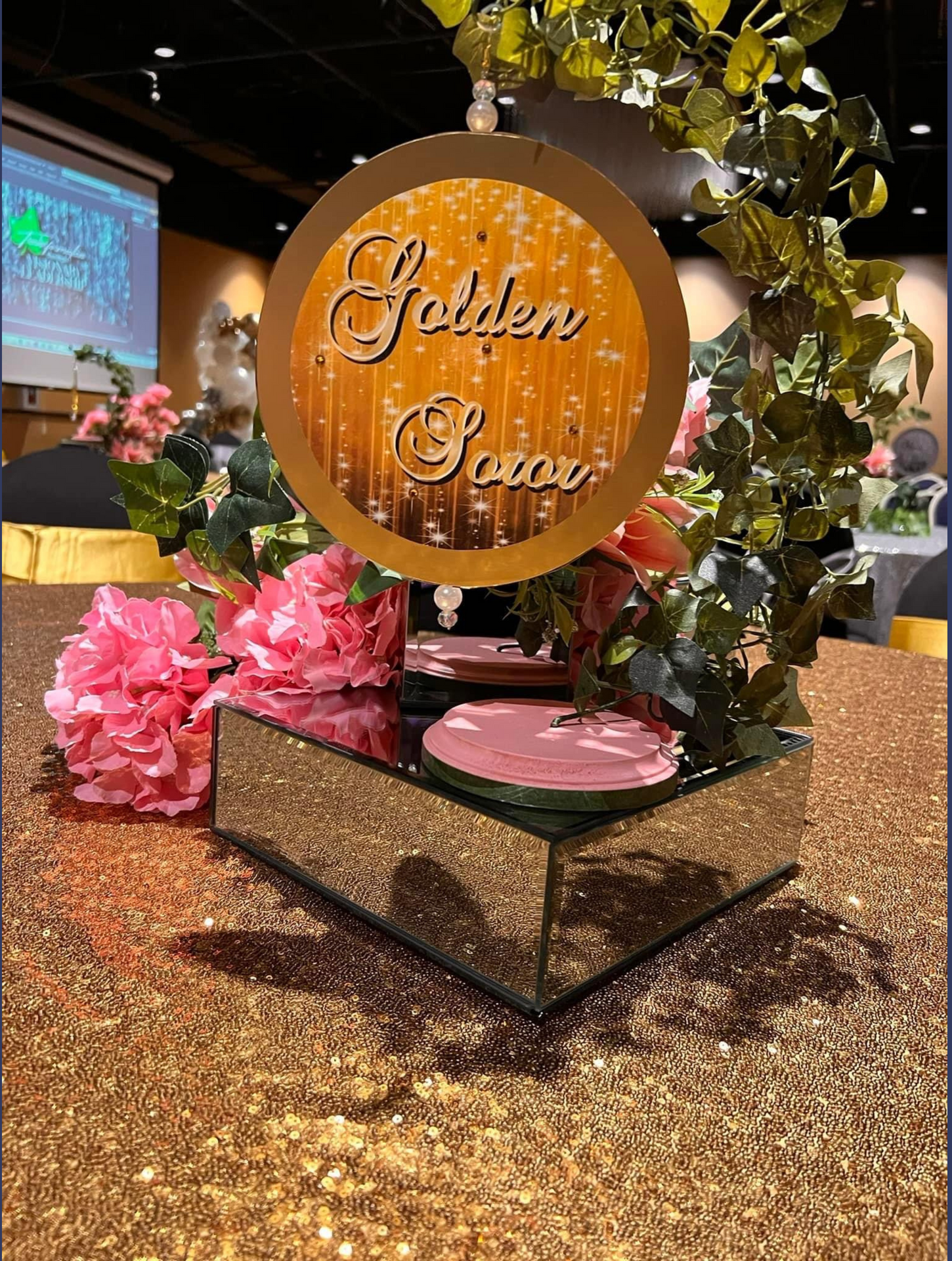 A table with a mirrored centerpiece and flowers on it.