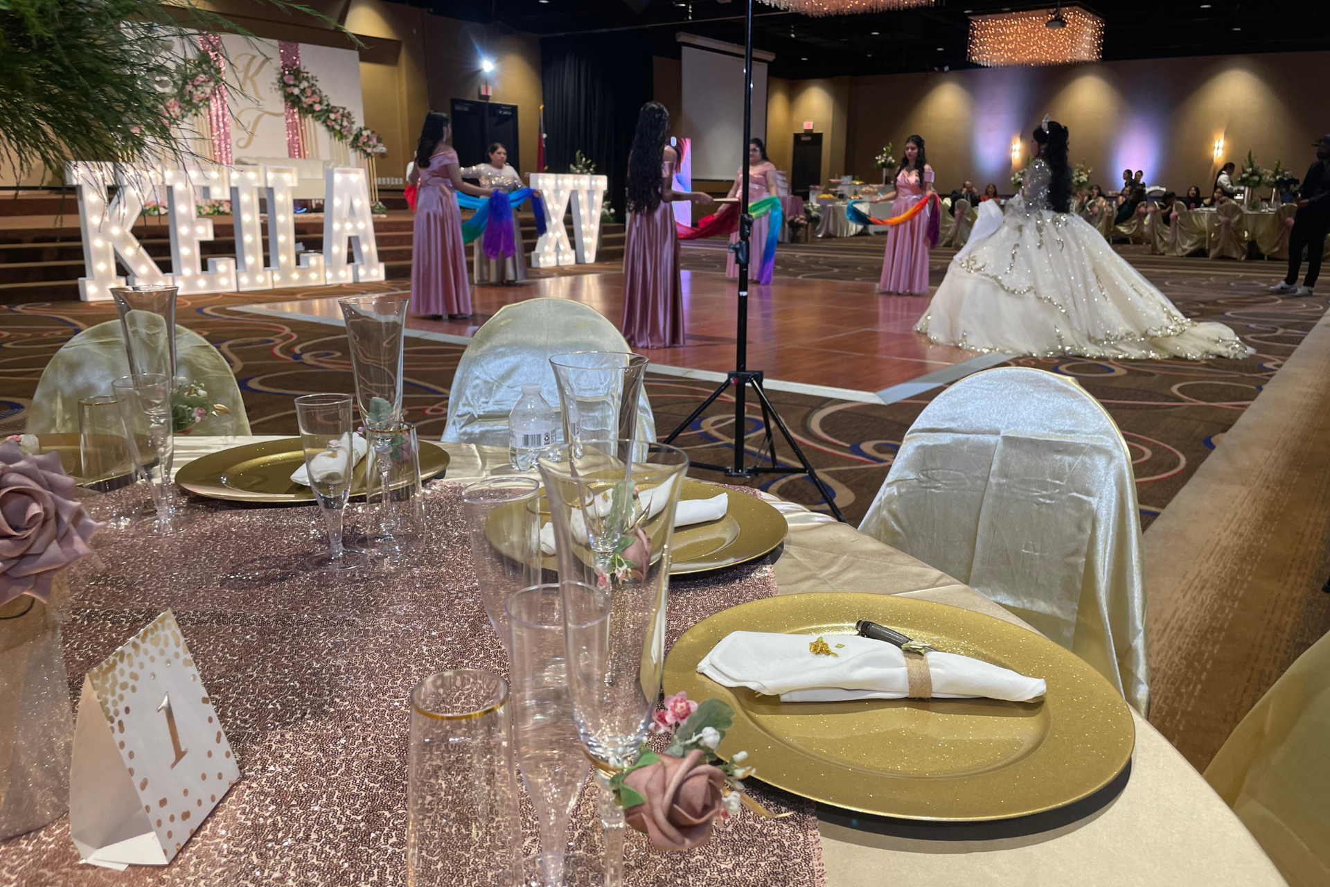 A table set up for a quinceañera with a sign that says 