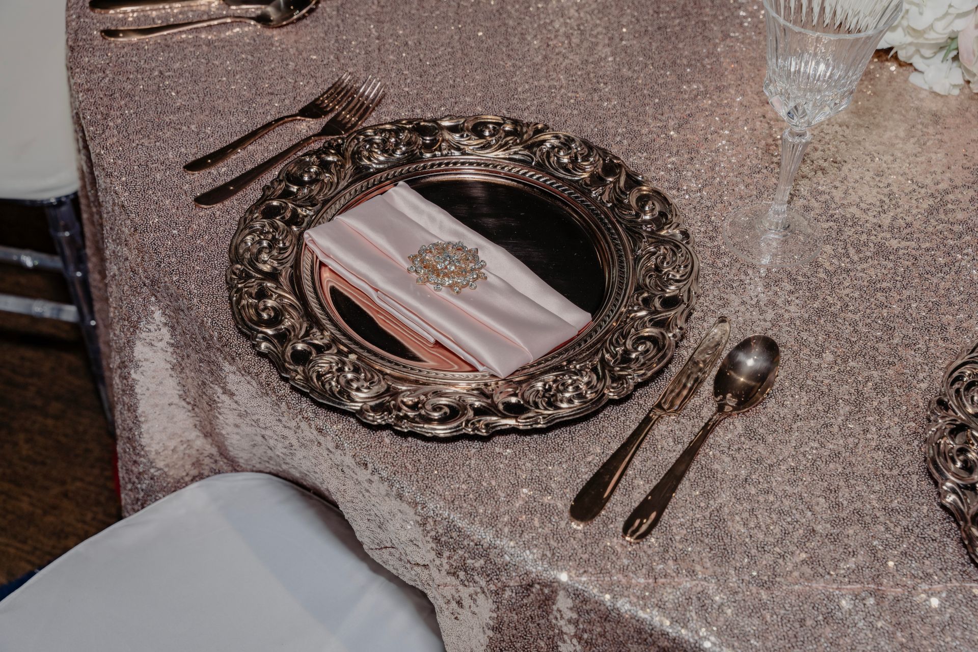 A plate with a napkin on it is on a table with silverware.
